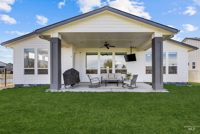 rear view of property featuring a patio area, ceiling fan, a yard, and an outdoor living space