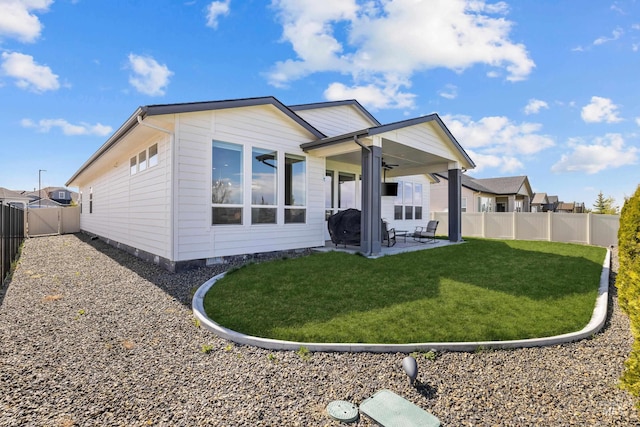 rear view of house featuring ceiling fan, a lawn, and a patio area