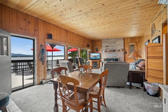 carpeted dining room with wood ceiling and wood walls