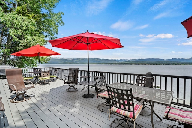 wooden deck with a water and mountain view