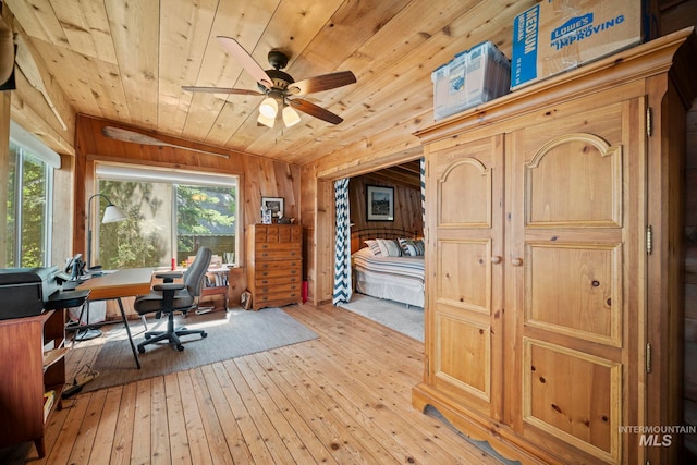 office space with ceiling fan, light hardwood / wood-style flooring, wooden ceiling, plenty of natural light, and wood walls