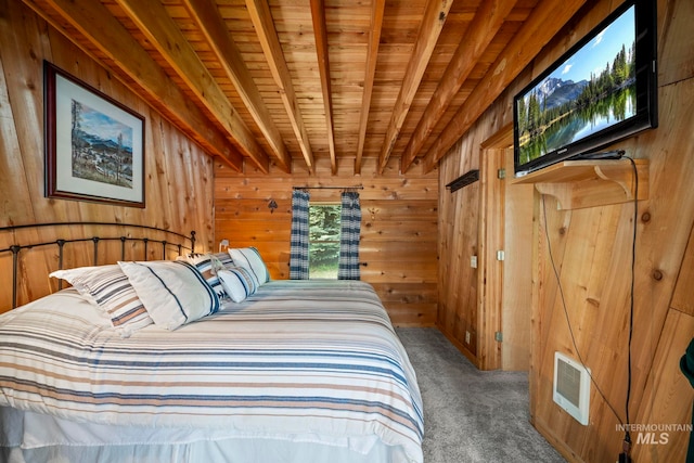 carpeted bedroom with beamed ceiling, wood ceiling, and wood walls