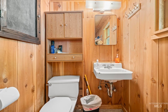 bathroom with toilet and wooden walls