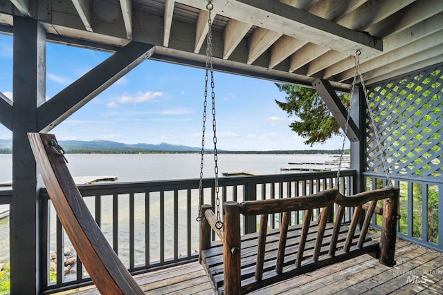 wooden deck with a water and mountain view