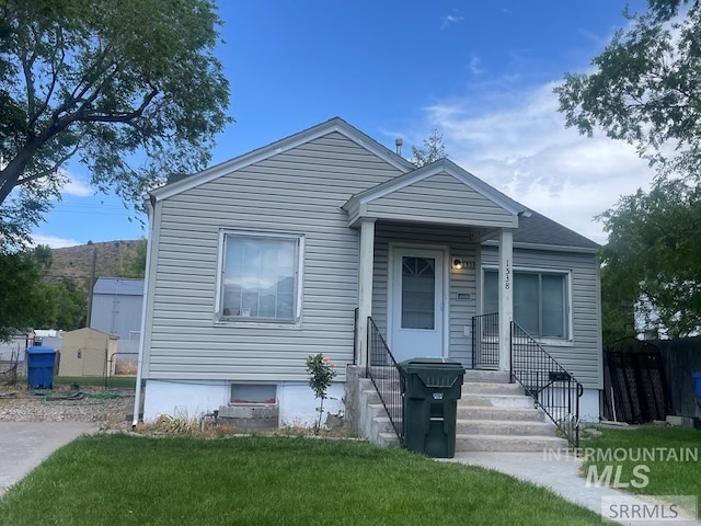 bungalow-style home with a front lawn