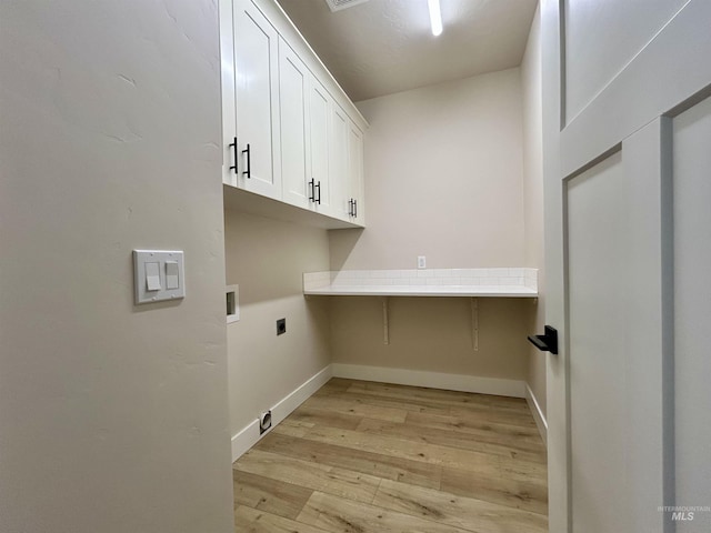 washroom with light wood-type flooring, baseboards, washer hookup, cabinet space, and electric dryer hookup