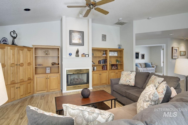3411 Wilson Ln, Nampa, ID 83686 - living room with light wood finished floors, a glass covered fireplace, and ceiling fan