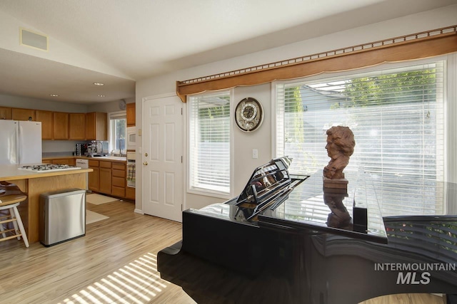 3411 Wilson Ln, Nampa, ID 83686 - kitchen with light countertops, vaulted ceiling, freestanding refrigerator, light wood-type flooring, and recessed lighting
