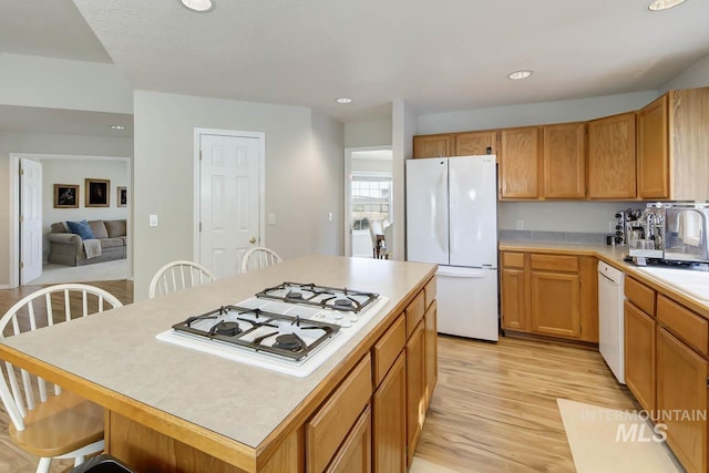 3411 Wilson Ln, Nampa, ID 83686 - kitchen featuring white appliances, light wood-style flooring, light countertops, recessed lighting, and a kitchen breakfast bar