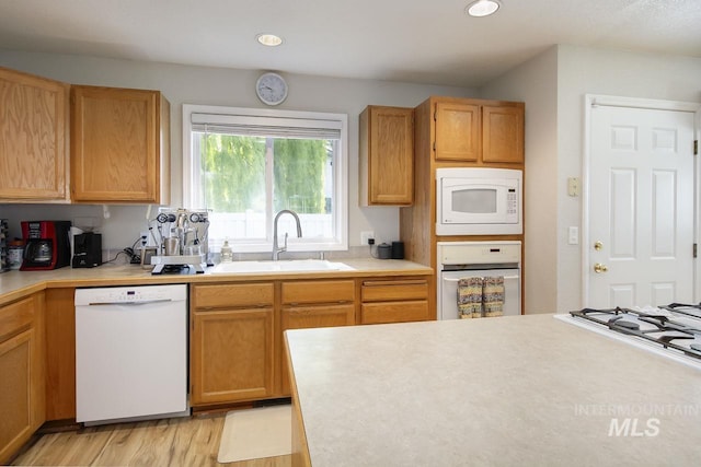 3411 Wilson Ln, Nampa, ID 83686 - kitchen with white appliances, a sink, light countertops, light wood-style floors, and recessed lighting