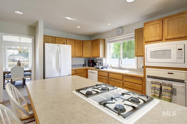 3411 Wilson Ln, Nampa, ID 83686 - kitchen with white appliances, light countertops, recessed lighting, a sink, and a chandelier