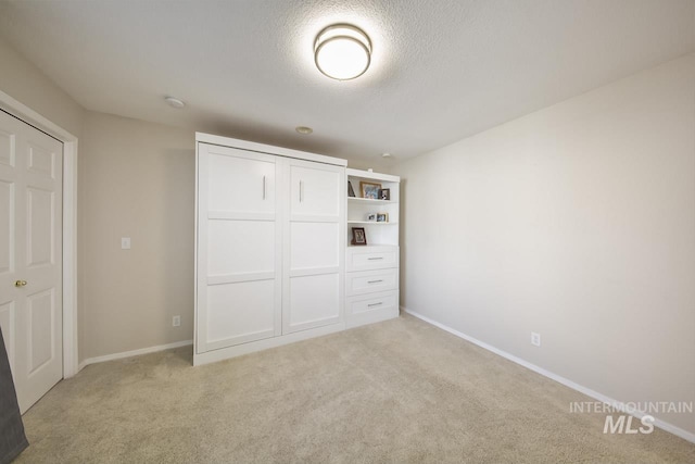 3411 Wilson Ln, Nampa, ID 83686 - unfurnished bedroom featuring light colored carpet, a closet, baseboards, and a textured ceiling
