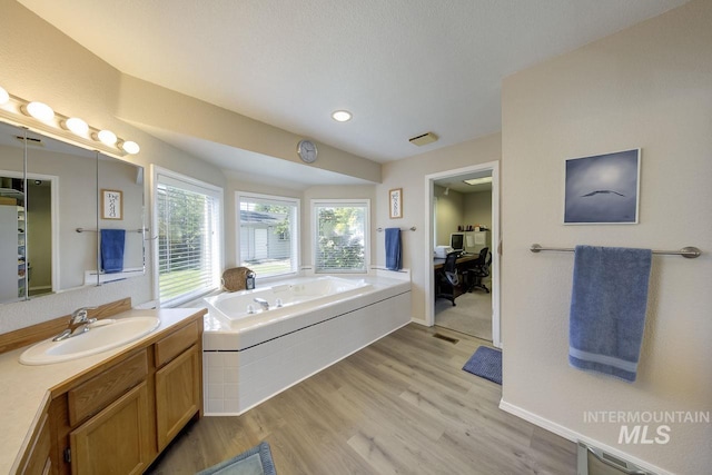 3411 Wilson Ln, Nampa, ID 83686 - bathroom with a bath, vanity, wood finished floors, baseboards, and recessed lighting