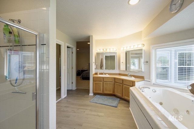 3411 Wilson Ln, Nampa, ID 83686 - full bathroom with a shower stall, wood finished floors, a jetted tub, and double vanity