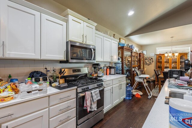 3744 S Antler Rdg, Boise, ID 83709 - kitchen with appliances with stainless steel finishes, light countertops, decorative backsplash, dark wood-style flooring, and lofted ceiling