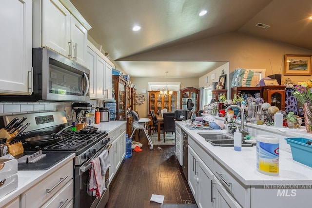 3744 S Antler Rdg, Boise, ID 83709 - kitchen with stainless steel appliances, a sink, vaulted ceiling, a chandelier, and dark wood finished floors
