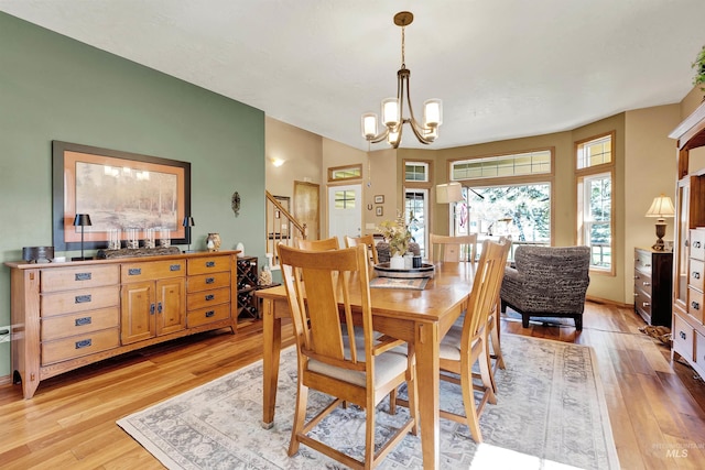 dining room with light wood-style floors, a chandelier, and stairway