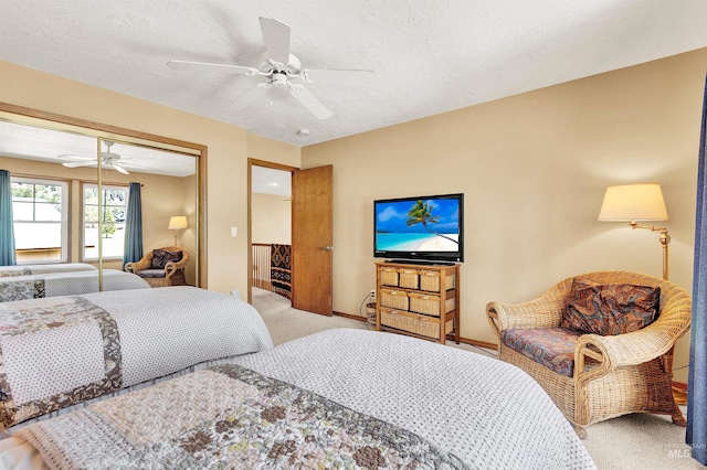 carpeted bedroom featuring a ceiling fan, a closet, and baseboards