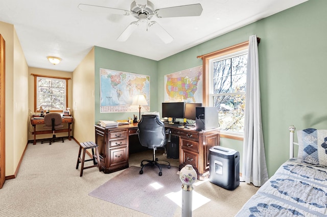 bedroom with light colored carpet, an office area, multiple windows, and baseboards
