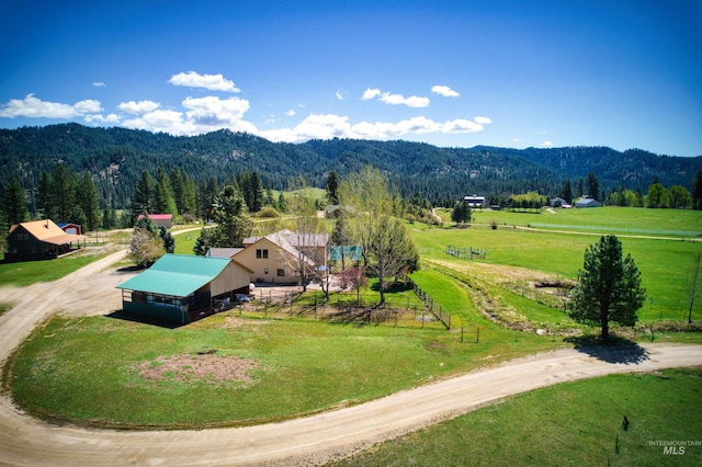 aerial view of sparsely populated area with mountains and a forest