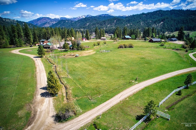 aerial view of sparsely populated area with mountains and a forest