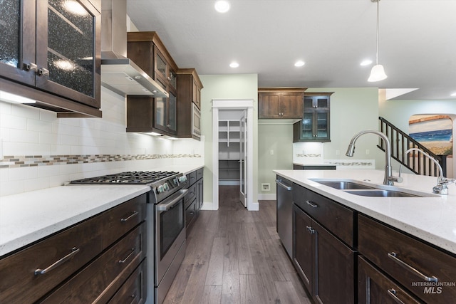 1031 E Reflect Ridge Dr, Meridian, ID 83642 - kitchen featuring appliances with stainless steel finishes, wall chimney range hood, a sink, hanging light fixtures, and backsplash