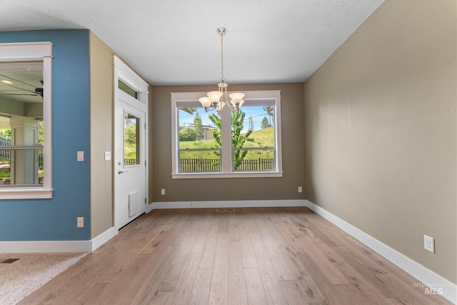 1031 E Reflect Ridge Dr, Meridian, ID 83642 - unfurnished dining area with a chandelier, hardwood / wood-style flooring, a ceiling fan, and baseboards