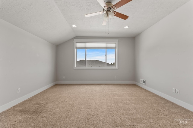 1031 E Reflect Ridge Dr, Meridian, ID 83642 - empty room featuring a textured ceiling, light carpet, lofted ceiling, a ceiling fan, and baseboards