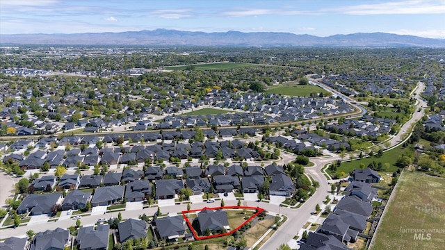 1031 E Reflect Ridge Dr, Meridian, ID 83642 - aerial overview of property's location featuring a mountain backdrop, property boundaries highlighted, and nearby suburban area