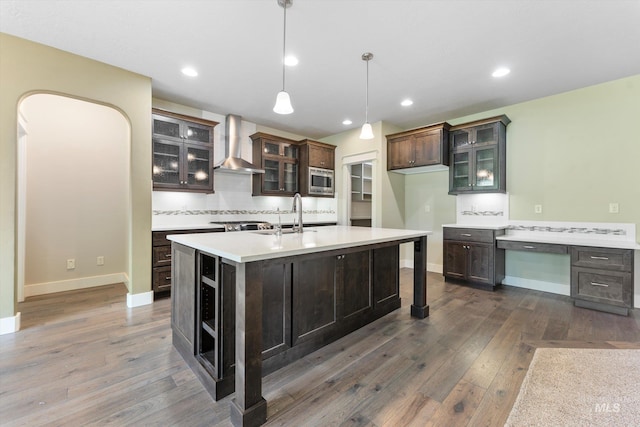 1031 E Reflect Ridge Dr, Meridian, ID 83642 - kitchen with wall chimney exhaust hood, a sink, dark wood-style floors, light countertops, and an island with sink