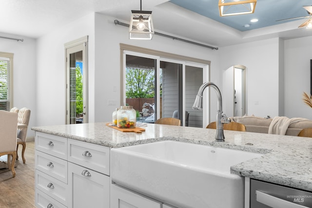 5853 W Venetian Dr, Eagle, ID 83616 - kitchen featuring a sink, light wood-style flooring, white cabinetry, light stone counters, and decorative light fixtures