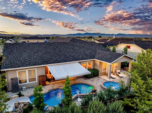 5853 W Venetian Dr, Eagle, ID 83616 - view of swimming pool with an in-ground hot tub, a patio, fence, and a mountain view