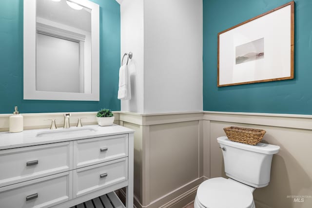 5853 W Venetian Dr, Eagle, ID 83616 - bathroom featuring toilet, a wainscoted wall, vanity, and a decorative wall