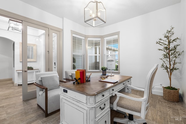 5853 W Venetian Dr, Eagle, ID 83616 - home office with arched walkways, a chandelier, light wood-style floors, and baseboards