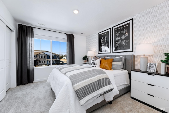 bedroom featuring light carpet and a closet