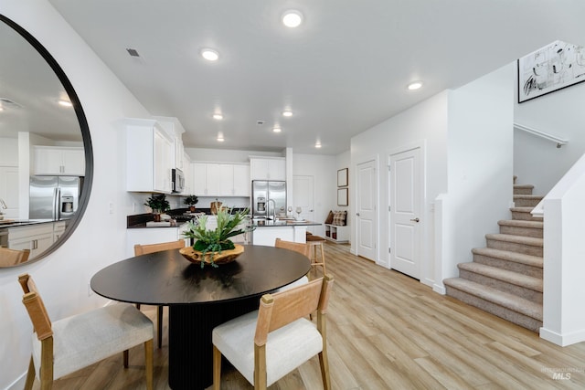 dining room with sink and light wood-type flooring