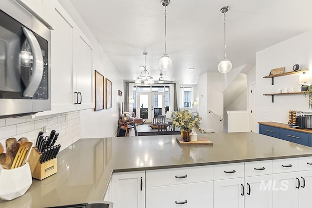 kitchen featuring pendant lighting, french doors, decorative backsplash, and white cabinets