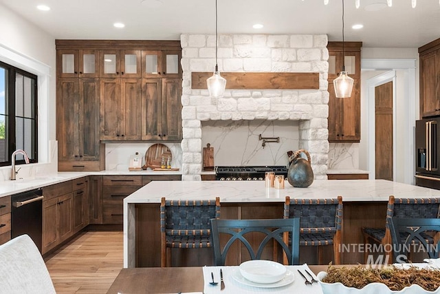 1195 N Arrano Farms Ln, Eagle, ID 83616 - kitchen featuring a sink, stainless steel appliances, light wood-style floors, tasteful backsplash, and a kitchen bar