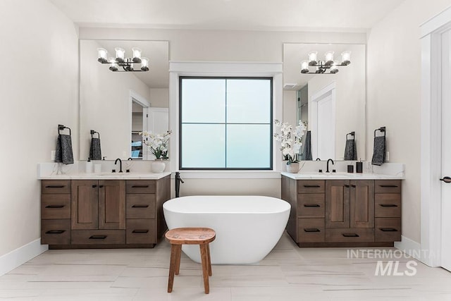 1195 N Arrano Farms Ln, Eagle, ID 83616 - bathroom featuring a chandelier, two vanities, a soaking tub, and baseboards