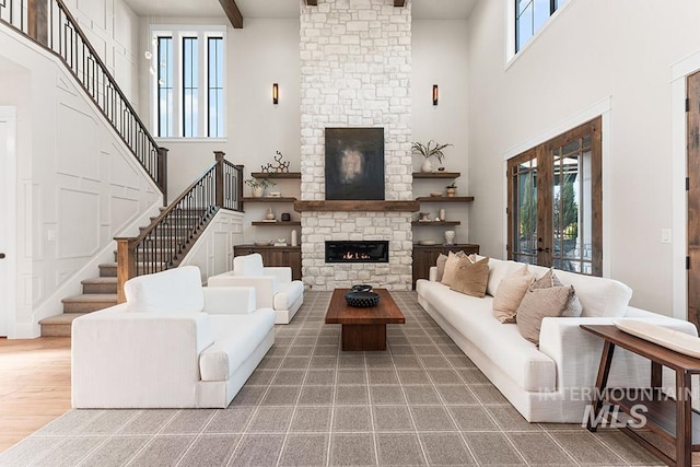 1195 N Arrano Farms Ln, Eagle, ID 83616 - living area with a high ceiling, a stone fireplace, stairway, wood finished floors, and beam ceiling