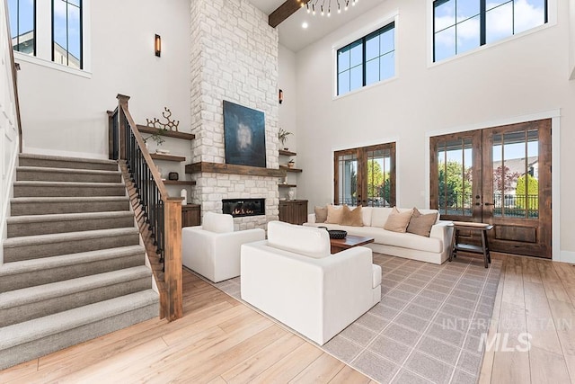 1195 N Arrano Farms Ln, Eagle, ID 83616 - living room featuring french doors, a fireplace, hardwood / wood-style flooring, a high ceiling, and stairs