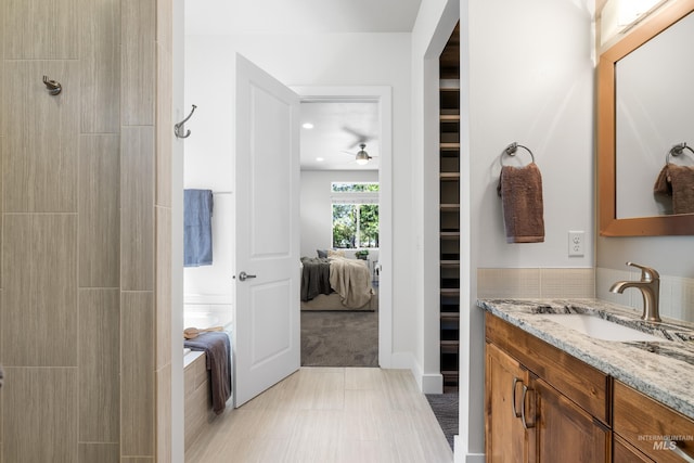 ensuite bathroom with vanity, ceiling fan, tile patterned floors, and ensuite bath