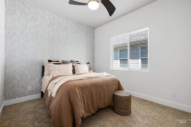 carpeted bedroom featuring baseboards, an accent wall, wallpapered walls, and ceiling fan