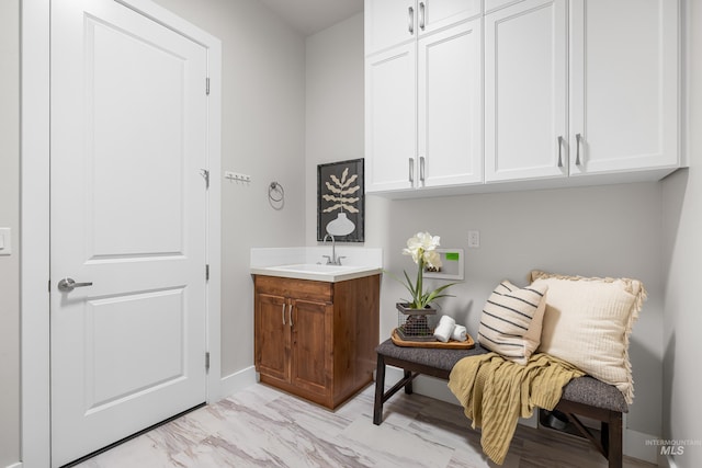 interior space with baseboards, a sink, and marble finish floor