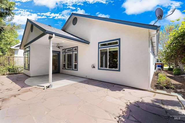 rear view of house with a patio, ceiling fan, and stucco siding