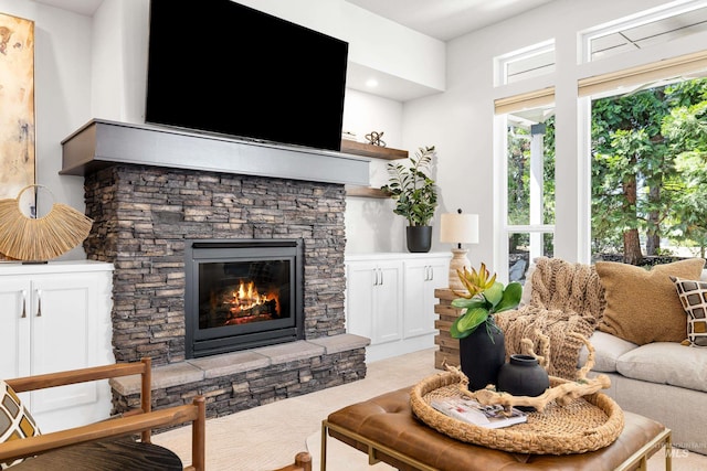living room with light colored carpet, a healthy amount of sunlight, and a fireplace