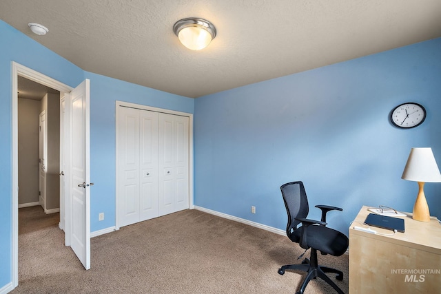 office space with baseboards, a textured ceiling, and carpet floors