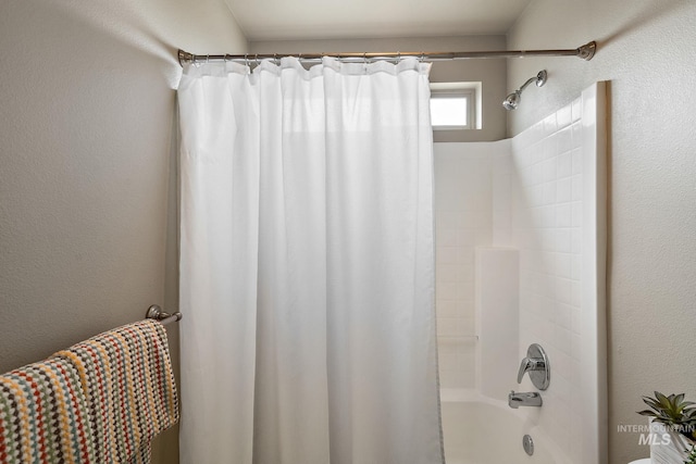 full bathroom with shower / bath combination with curtain and a textured wall