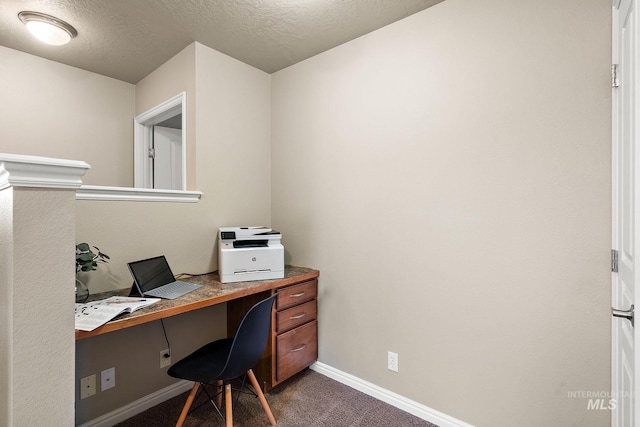 office space with baseboards, dark carpet, and a textured ceiling