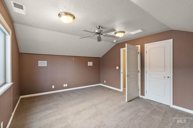 bonus room with light colored carpet, ceiling fan, visible vents, and a textured ceiling